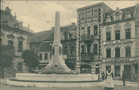 Alte Ansichtskarte Osterode / Ostróda, Platz mit Brunnen, Conditorei Kurt Trotzki