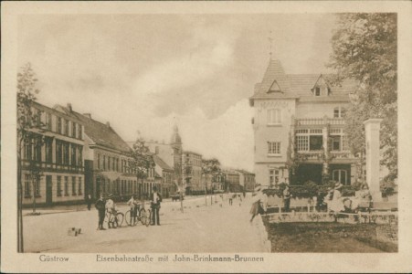 Alte Ansichtskarte Güstrow, Eisenbahnstraße mit John-Brinkmann-Brunnen