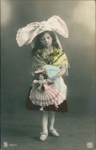 Alte Ansichtskarte Mädchen mit großer Schleife im Haar und Puppe im Arm, 