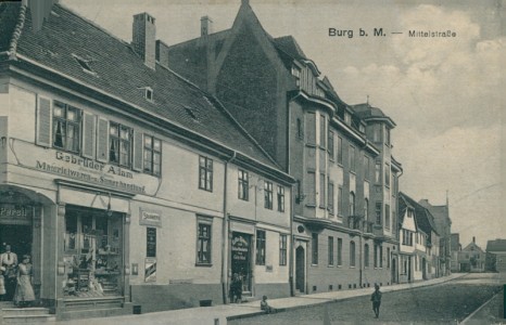 Alte Ansichtskarte Burg b. Magdeburg, Mittelstraße mit Materialwaren- u. Samenhandlung Gebrüder Adam