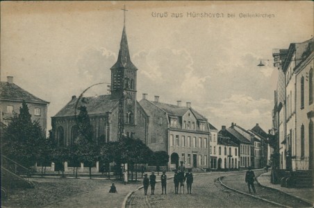 Alte Ansichtskarte Geilenkirchen-Hünshoven, Straßenpartie mit Kirche (OBERER RAND VERFÄRBT)